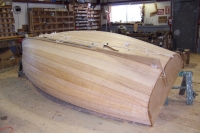 The hull is faired, caulked with cotton, plugged, and sanded.