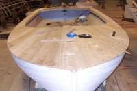Cedar planking is nailed to the deck structure, faired, and filled.