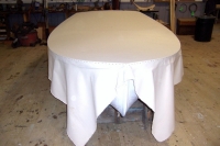 Cotton canvas is stapled overthe deck and primed with a thin coat of paint